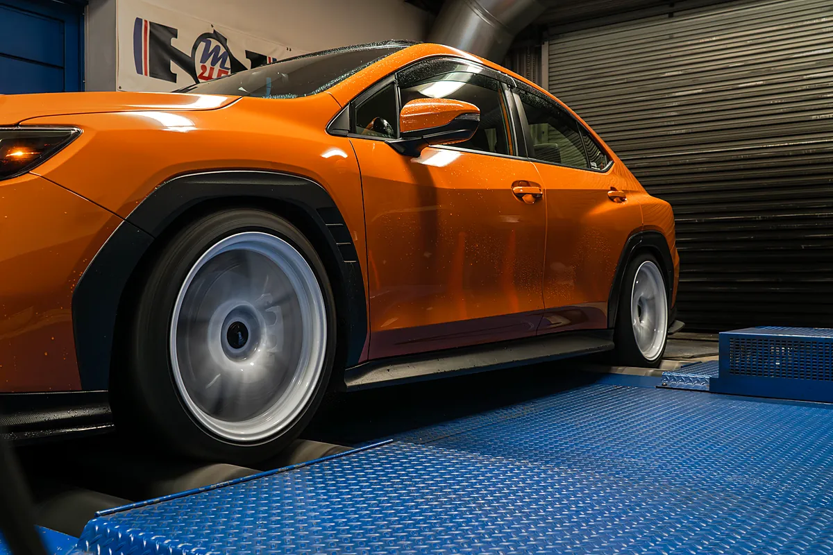 Orange WRX spinning up on the dyno rollers