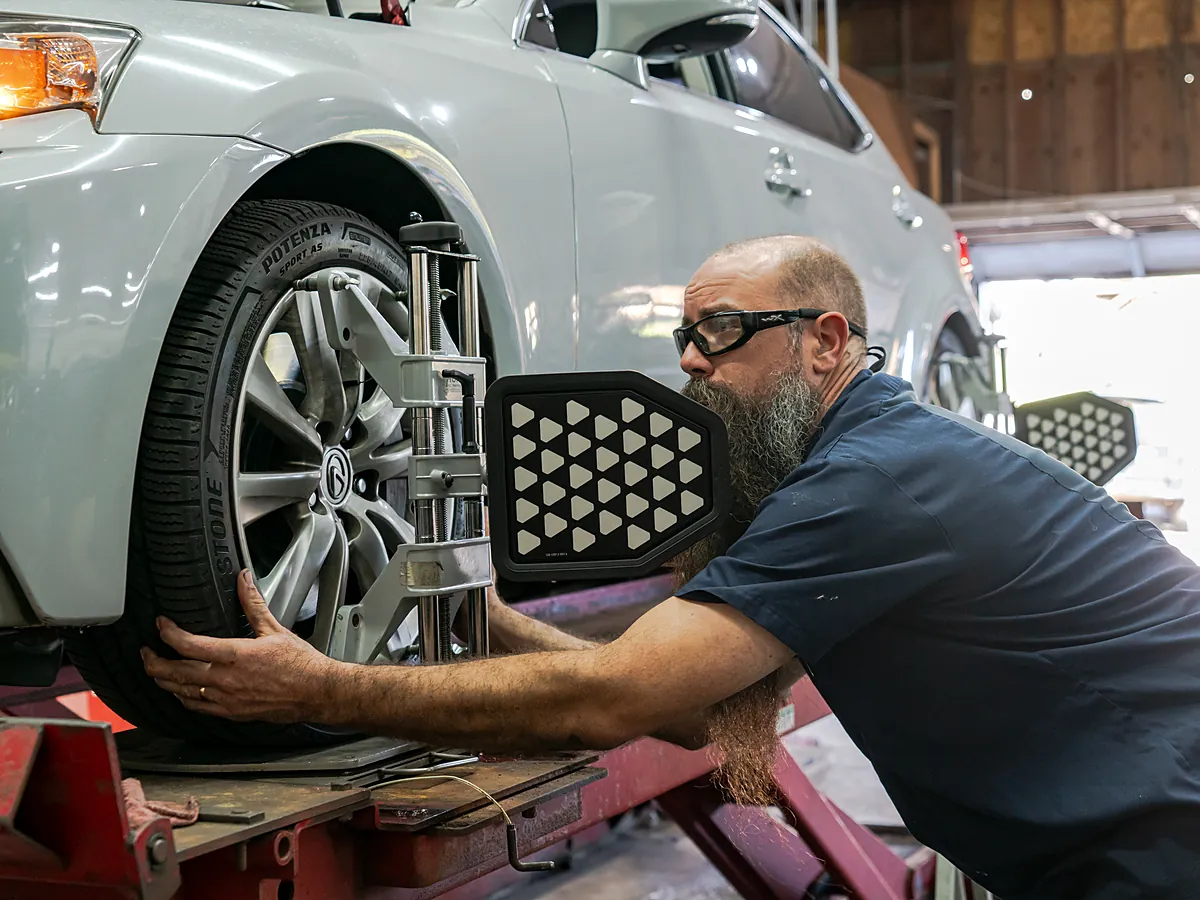 Tech mounting an alignment target on a wheel