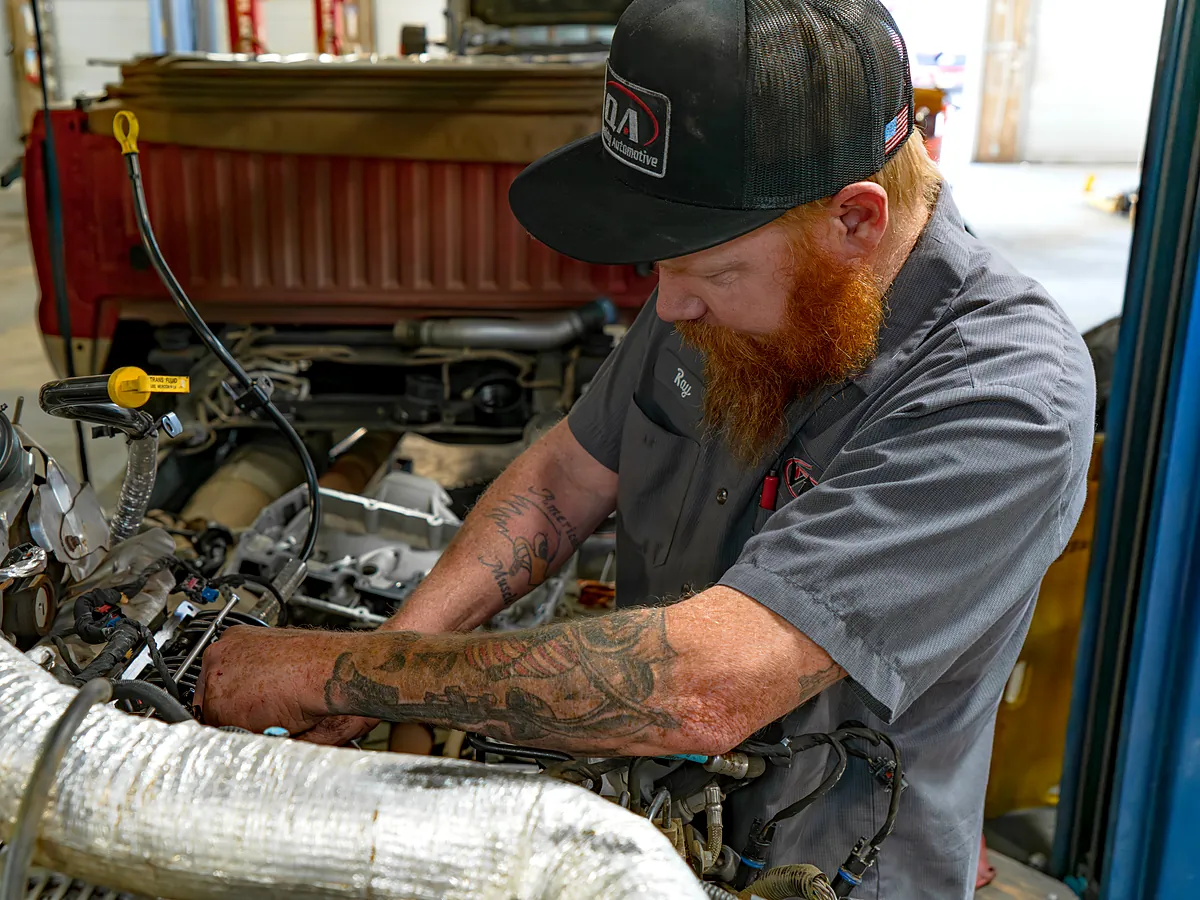 Tech working over an open engine bay